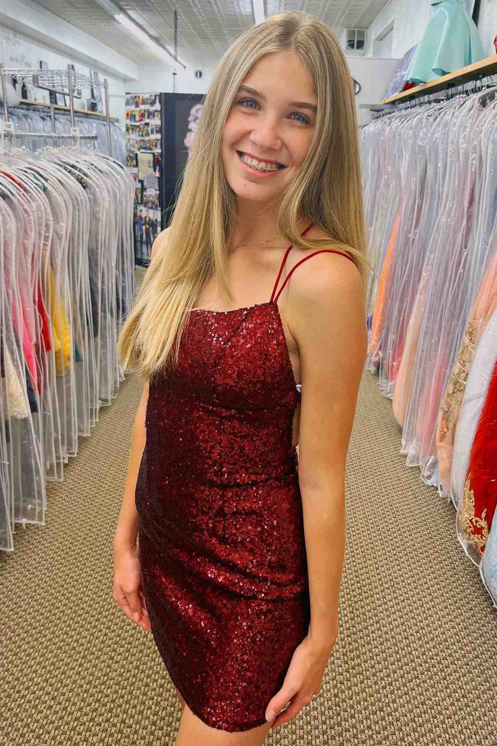 This tight short homecoming dress features hater neckline and sequins